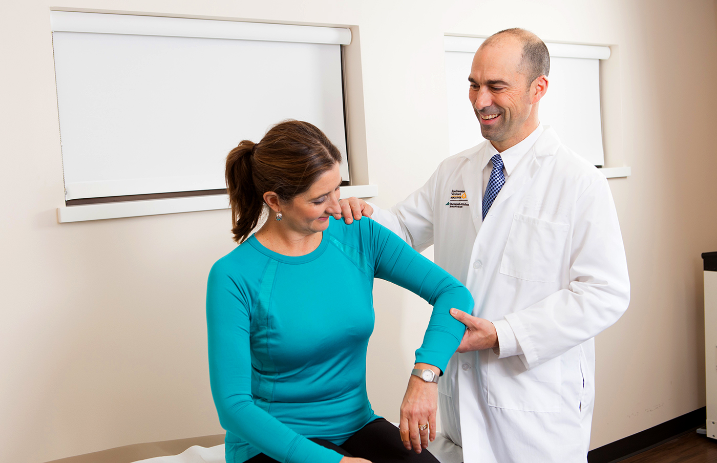 Provider examining a patient's arm in an examination room