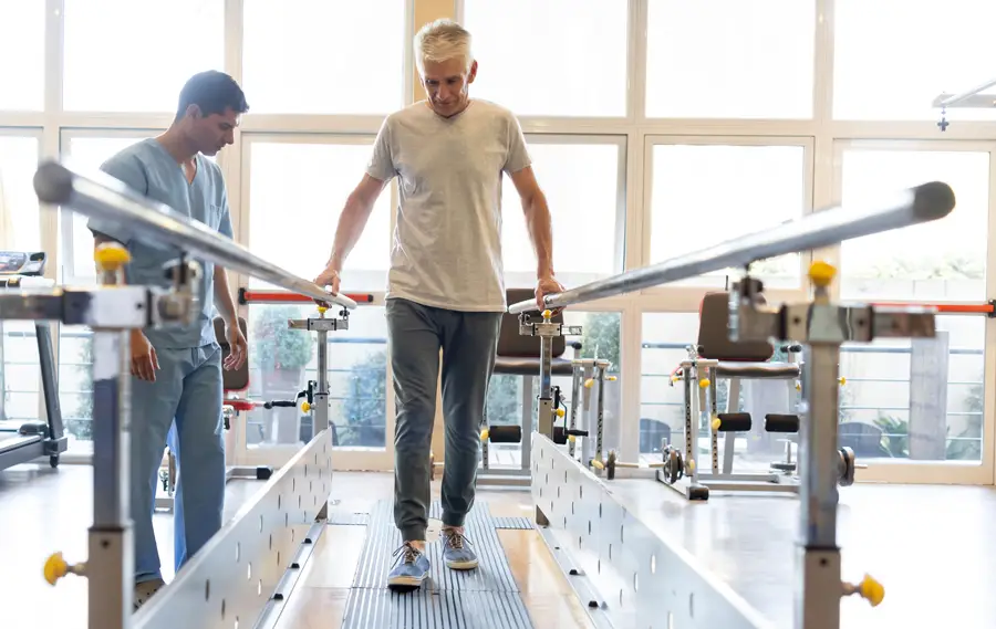 Man doing physical therapy on a treadmill while provider supervises