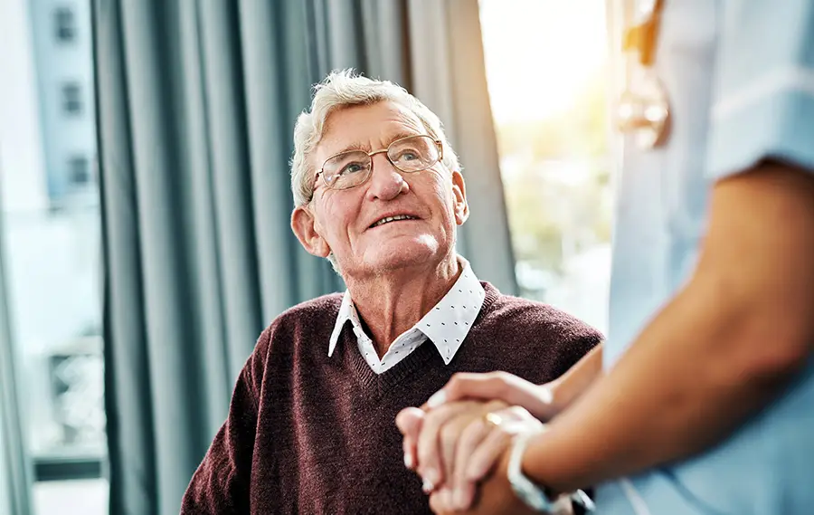 Provider holding hands with elderly patient
