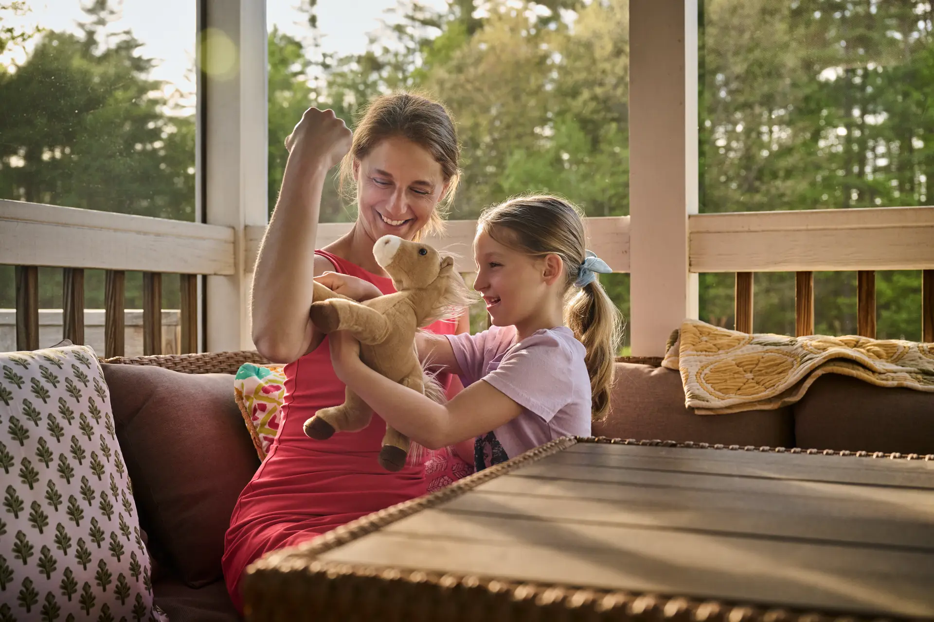 A woman and child seated at an outdoor table, playing together