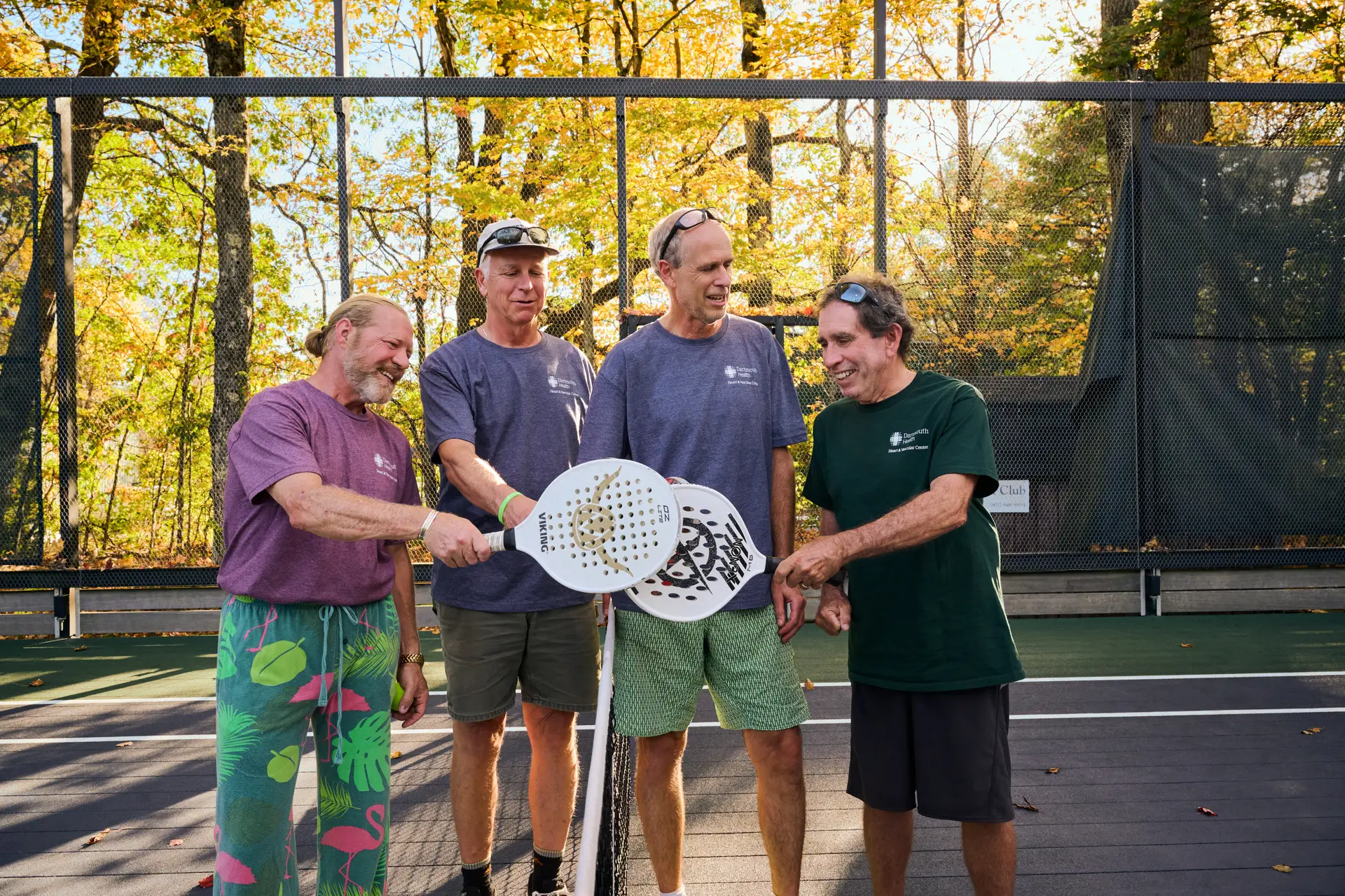 4 men holding pickleball rackets
