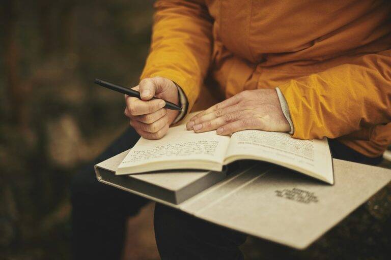 Person writing in a small book