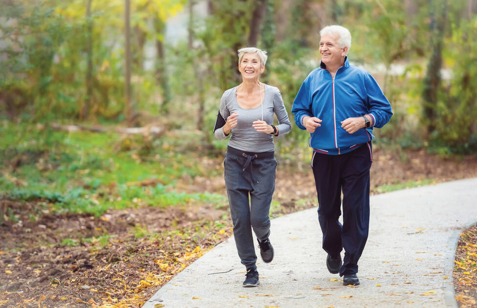 Two people jogging on an outdoor trail in the fall