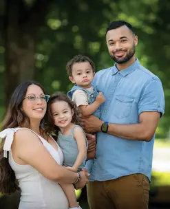 Parents holding their young children in a park