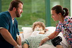 Two nurses simulate health care with dummy