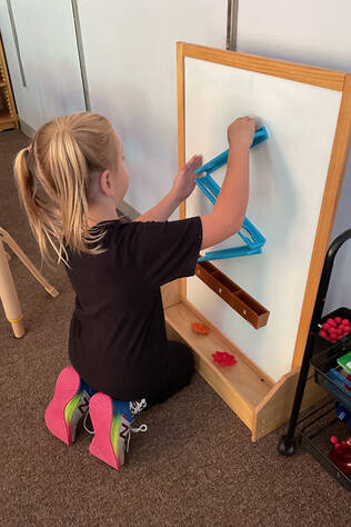 A child plays with a gear toy at the Children's Learning Center at Cheshire Medical Center