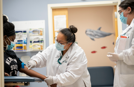 Two phlebotomists with a patient