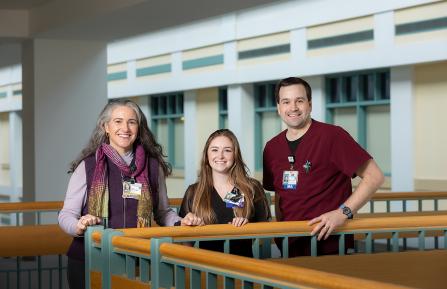Susanne E. Tanski, MD, Jasmin J. Ward, MA II, and Daniel P. Hollander, MA II standing against a railing inside Dartmouth Hitchcock Medical Center