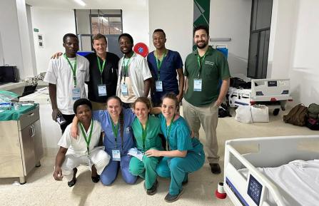 Joseph Romine, Elizabeth Planz, RN, and Emily Stitt pose for a photo with partners from Munini Hospital in Rwanda