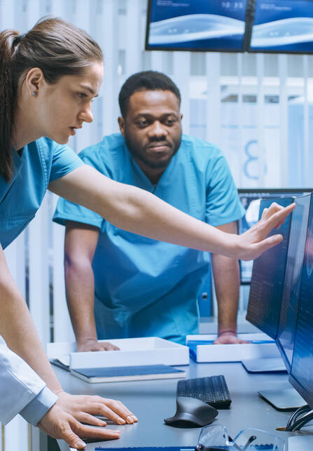a female healthcare provider points at a screen while a male provider watches