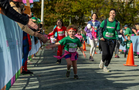 Ella, 4, and mom Aime Mason, of Norwich, VT, crossing the finish line of Cam's Course 1-mile fun run at the 20th annual CHaD HERO on October 19.