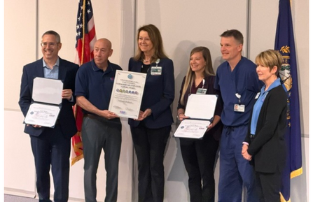 A group of people stand holding their awards.