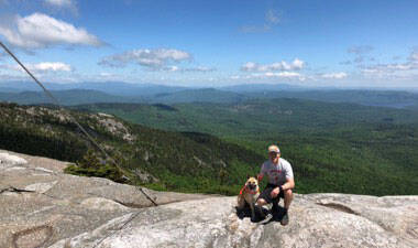 Dog and orthopaedic resident hikder at top of mountain.
