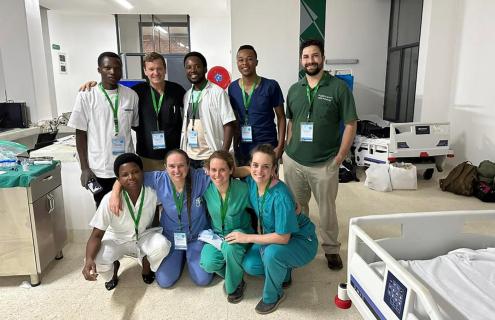 Joseph Romine, Elizabeth Planz, RN, and Emily Stitt pose for a photo with partners from Munini Hospital in Rwanda 