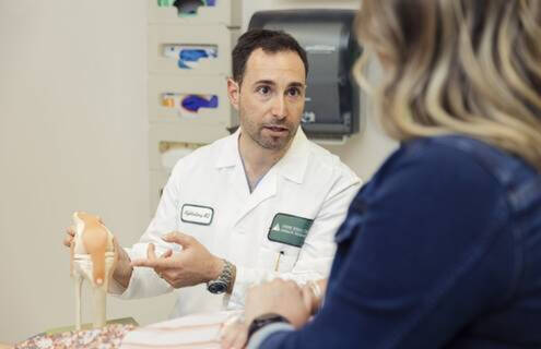 Neal B. Goldenberg, MD, MA, an orthopaedic surgeon and chair of sports medicine at Dartmouth Health’s Cheshire Medical Center, displays a model of the bones and tendons of the knee.