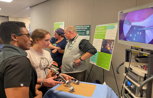 Kai Britton of Hartland, VT, participates in a laparoscopic procedure demonstration using a Lite Brite® toy at Dartmouth Health’s 2023 Career Expo.