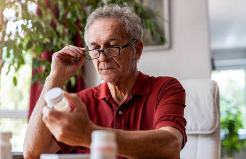 Man looking at pill bottle