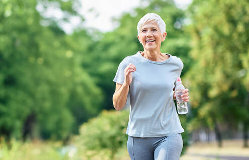woman running outside with bottled water