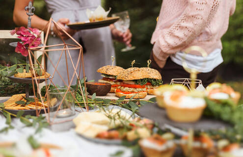 A lunch spread on a table outside with two people chatting