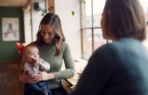 Woman talking with another woman with a baby