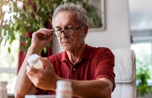 Man looking at pill bottle