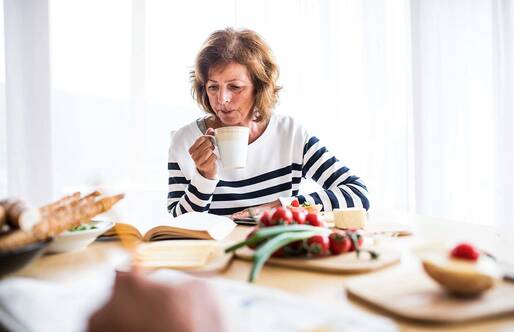 woman reviewing information while sitting at kitchen table