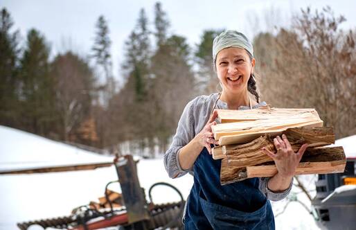 woman carrying a stack of wood 