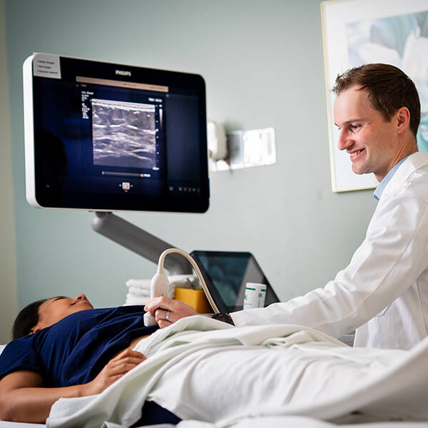 A provider performs and ultrasound exam on a patient
