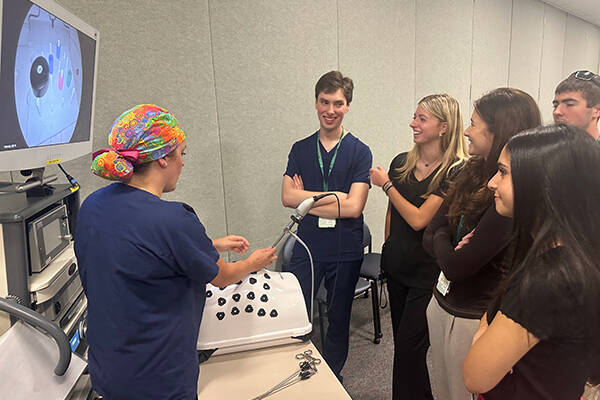 A group of students watching a medical equipment demonstration
