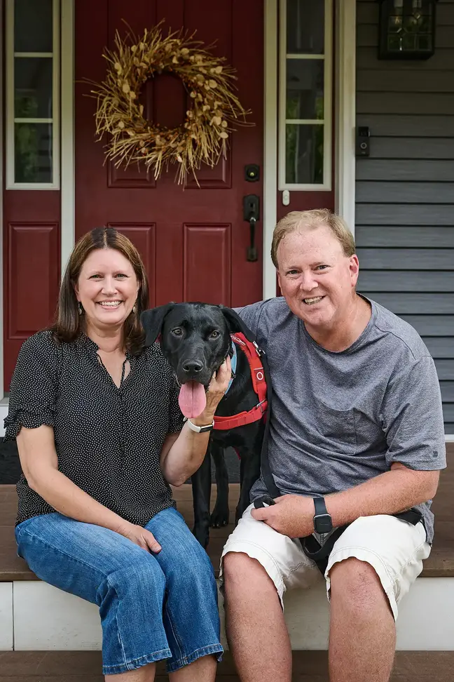 Lisa and Jeff Clark seated on their front porch with their dog