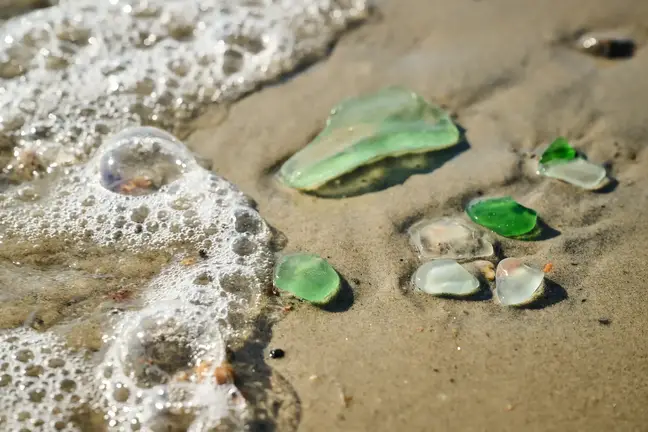 Jeff Clarks' hands examining small pieces of sea glass