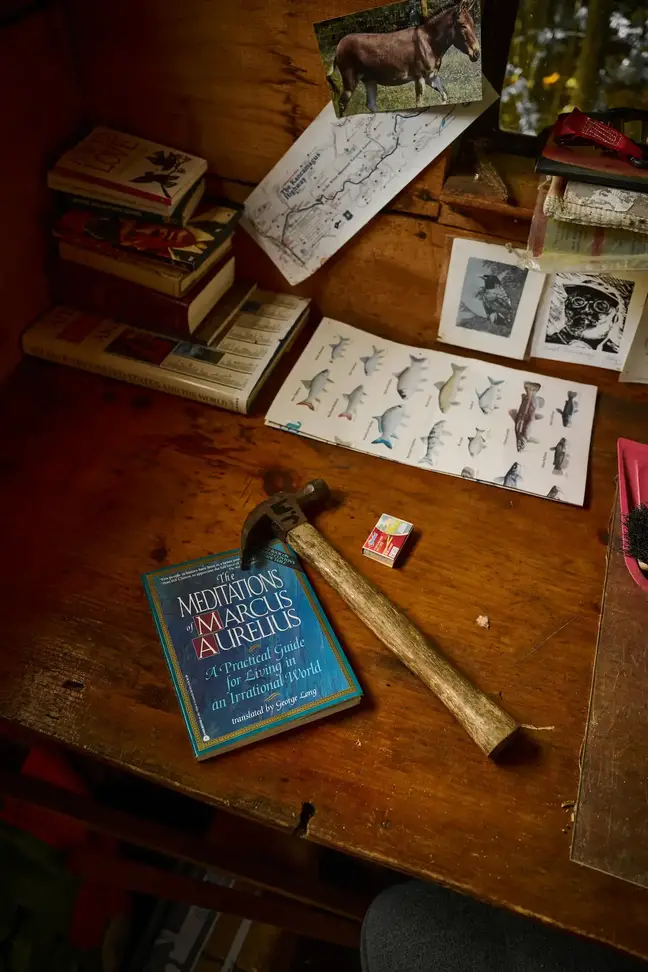 A workbench with a hammer and a book of Marcus Aurelius Meditations