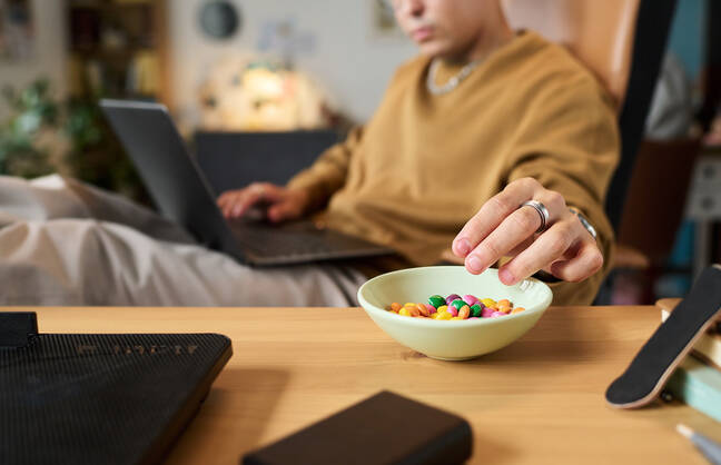 Man eating a bowl of M & M's.