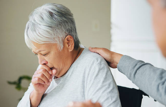 A sick older woman being comforted