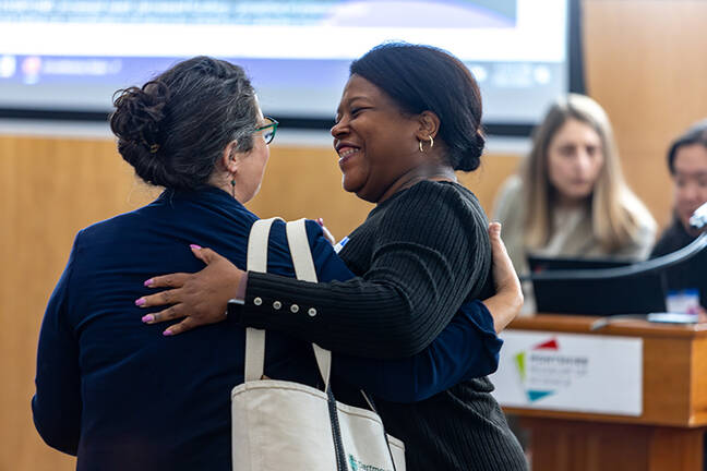 Two smiling CARHE Unconference participants embrace