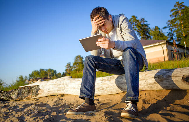 Man looking at a table with head in his hands.