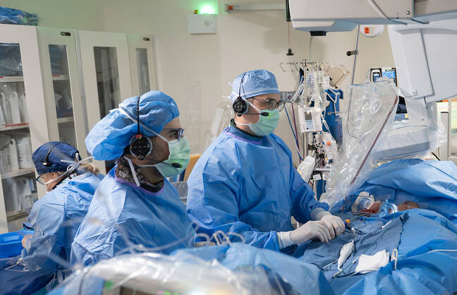 Doctor Robert D'Angelo, MD and Cardiac Electrophysiology Cardiac Fellow, Biwar Marof, MD, tending to a patient