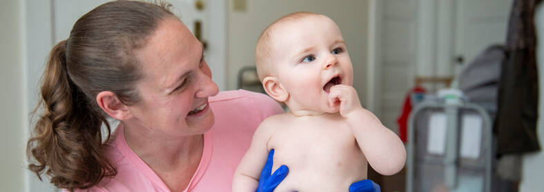 VNH nurse holding smiling infant